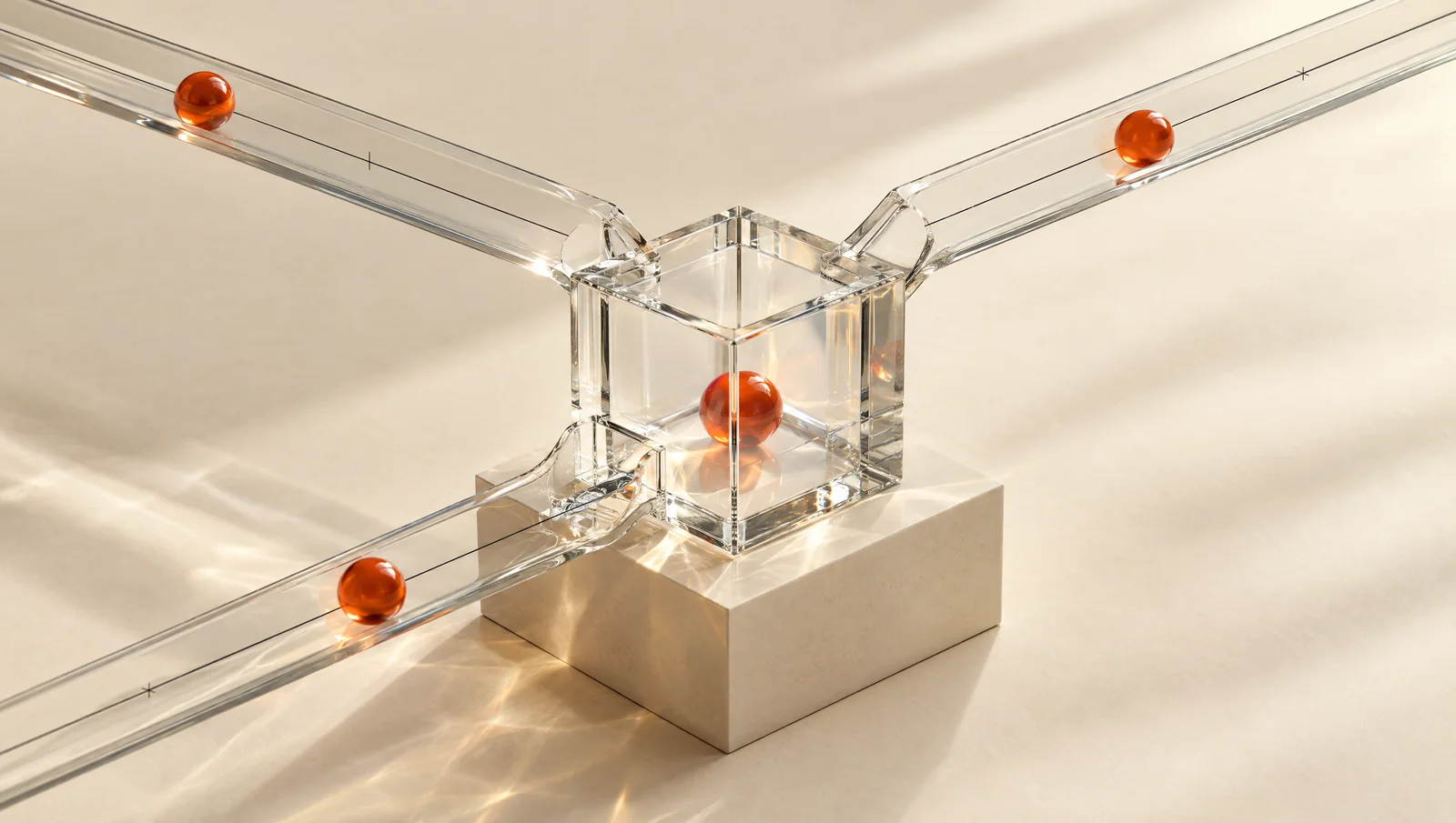 Glass channels lead to a measuring chamber containing separate orange spheres.